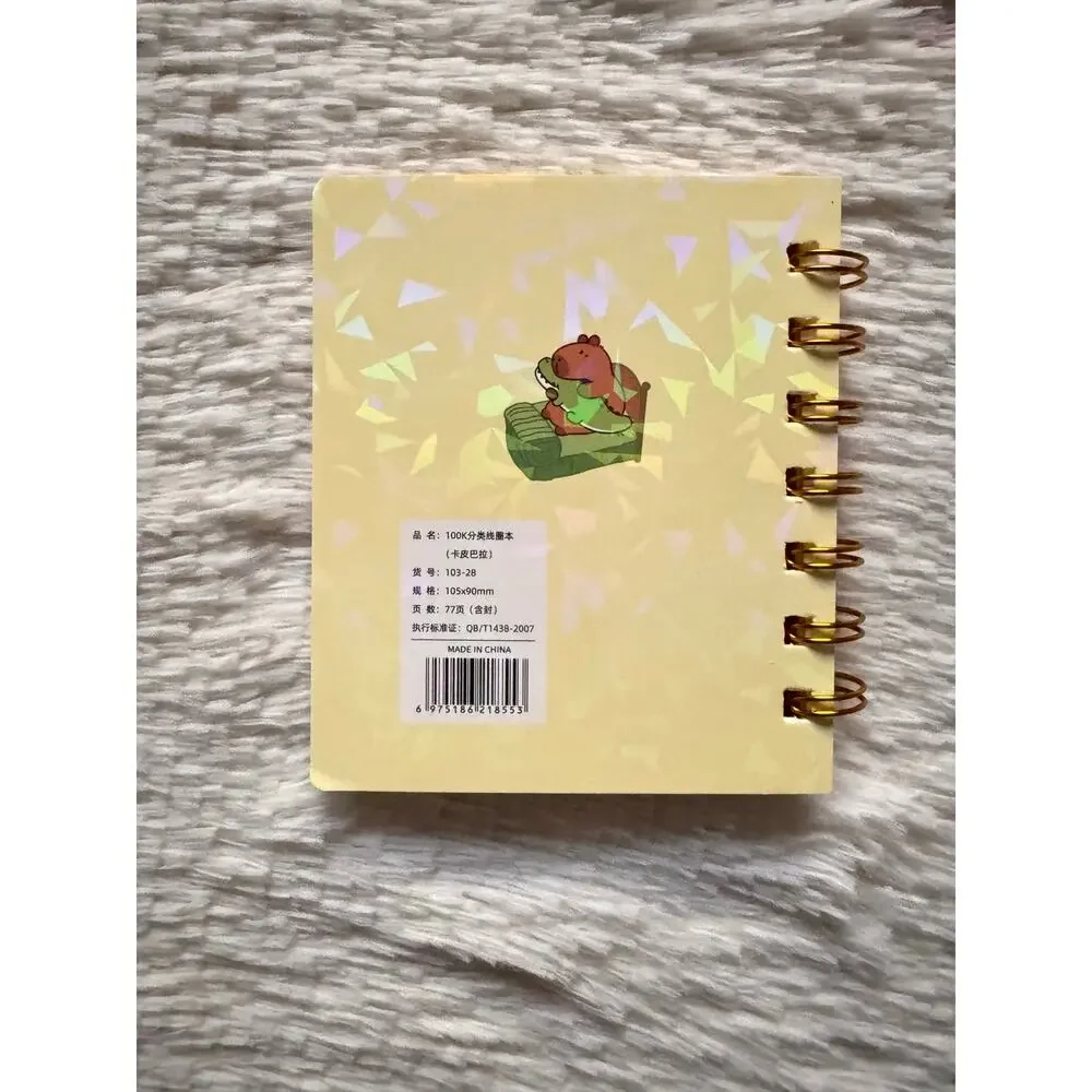 Capybara A6 spiral mini notebook with cute capybara with an alligator on a bed